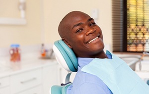 Man smiles while sitting in the dental chair