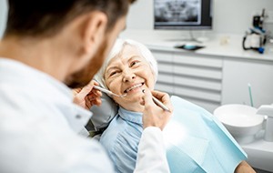 a patient getting her teeth checked by her dentist