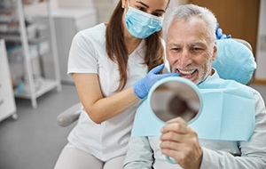 a patient checking his teeth with a mirror